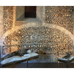 Capela dos Ossos is a chapel decorated with human bones located in Évora, Portugal. It was built in the 16th century by Franciscan monks with the aim of reflecting on the transience of life and human mortality. The bones that adorn the walls, columns and ceilings of the chapel come from approximately 5,000 monks, whose remains were exhumed from city to be used as decoration. In addition to the bones, the chapel also has inscriptions in Latin, such as "We bones that are here, we wait for yours".The chapel was built as a place of meditation and reflection on death, and is still an important place of pilgrimage and tourism in Évora today. Despite its somewhat morbid decoration, the Capela dos Ossos is considered an impressive work of art and one of the most visited attractions in the city.