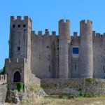 Óbidos is a medieval town in Portugal, surrounded by historic walls that protected the city for centuries. Óbidos Castle is the most prominent of its castles and was built by the Moors in the 12th century and renovated by the Portuguese in the 13th century. There are several other castles and fortifications within the city walls, which are well preserved. Today, Óbidos is a popular tourist destination, known for its cobbled streets, artisan shops and its annual chocolate festival.